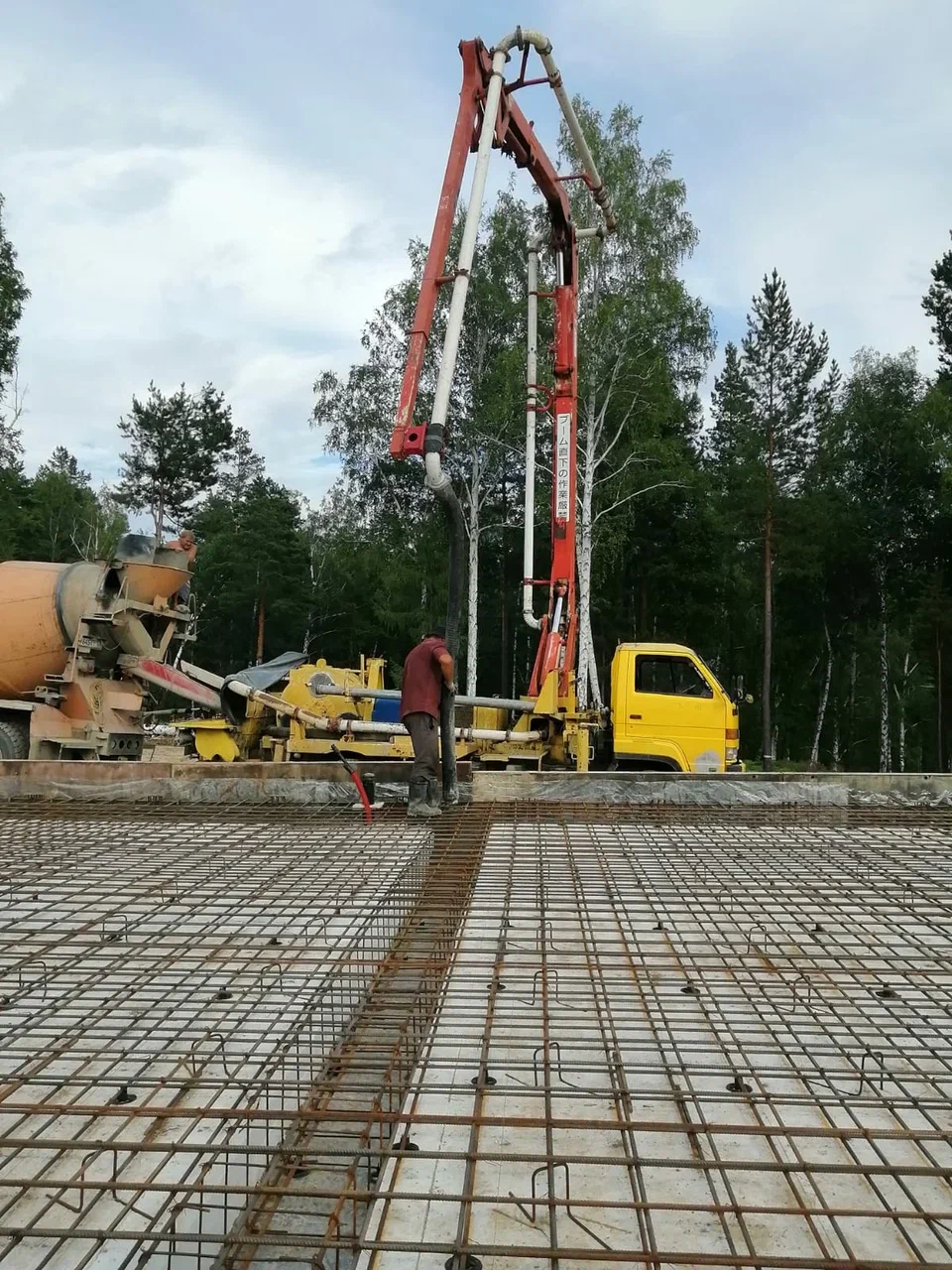 Автобетононасос над армированной плитой на лесном участке