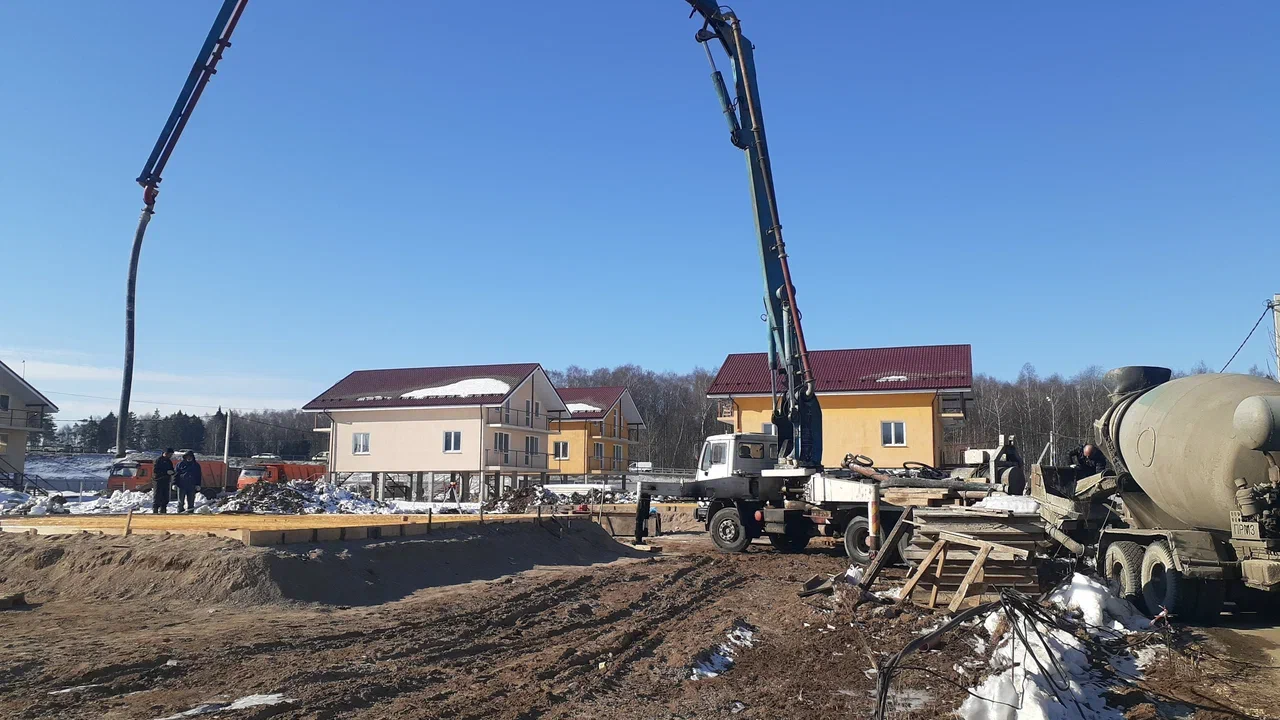 Два автобетононасоса и миксер на зимней строительной площадке